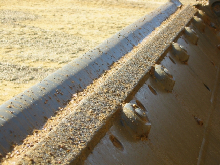 TC moldboard wear strip prevents scalloping between teeth