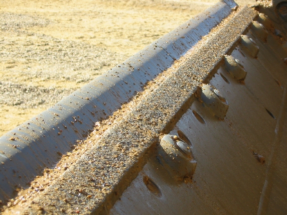 TC moldboard wear strip prevents scalloping between teeth